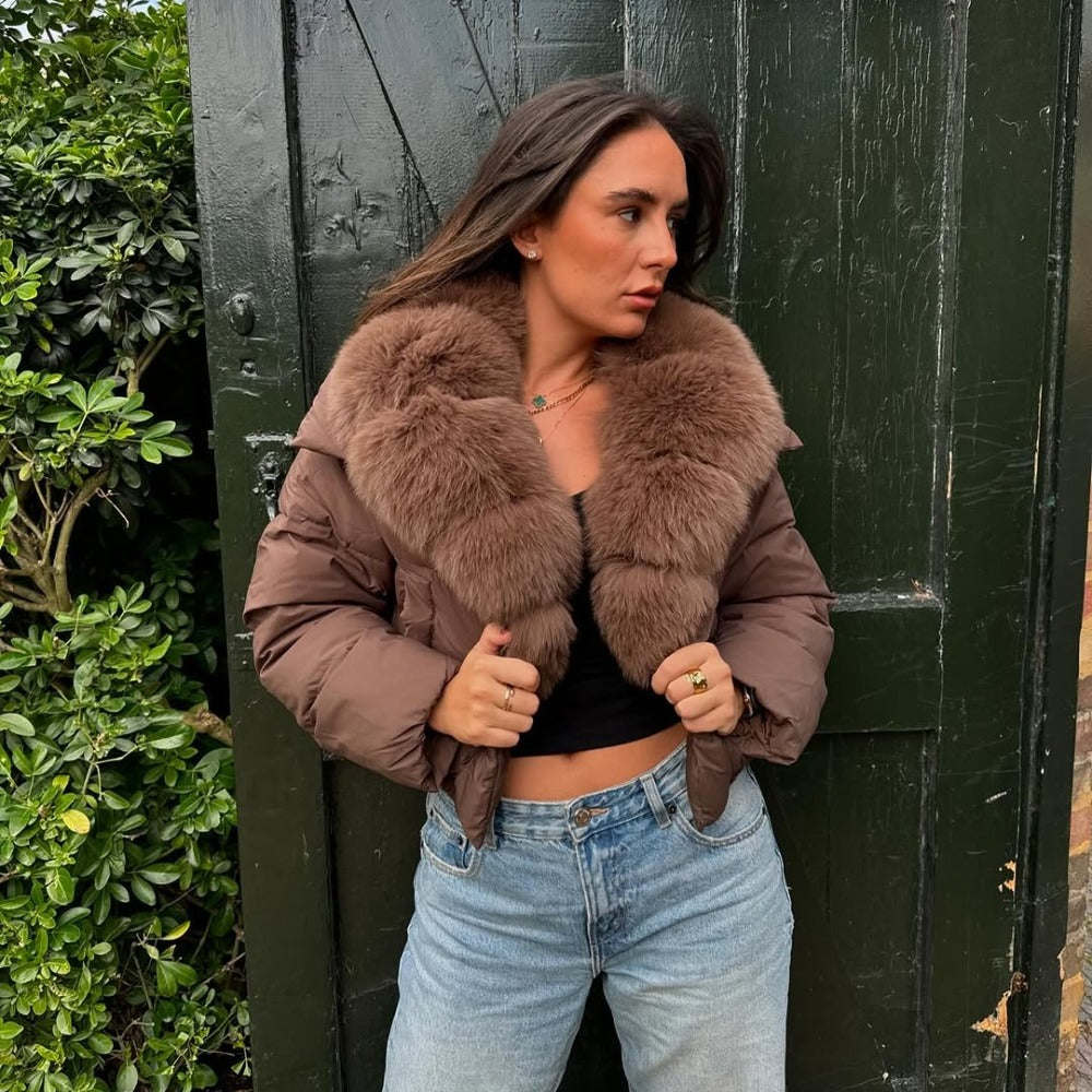 Close-up of a brown 90% down puffer jacket featuring a voluminous real fox fur shawl collar
