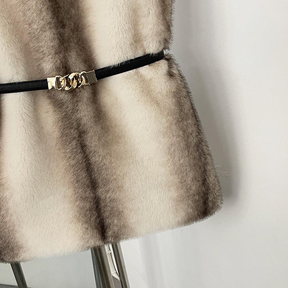 Detail of the slim black belt with gold buckle cinching the waist of a fur vest