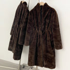 Two matching long faux mink coats showing relaxed fit silhouette