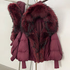 Woman wearing a vibrant rose red cropped down puffer with a massive matching real fur collar