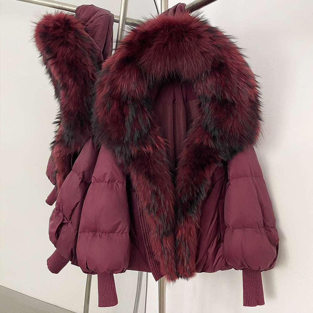 Woman wearing a vibrant rose red cropped down puffer with a massive matching real fur collar