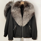 Front view of black bomber jacket featuring a voluminous silver fox fur collar