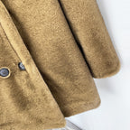 Detail shot of dark round double-breasted buttons on faux fur blazer