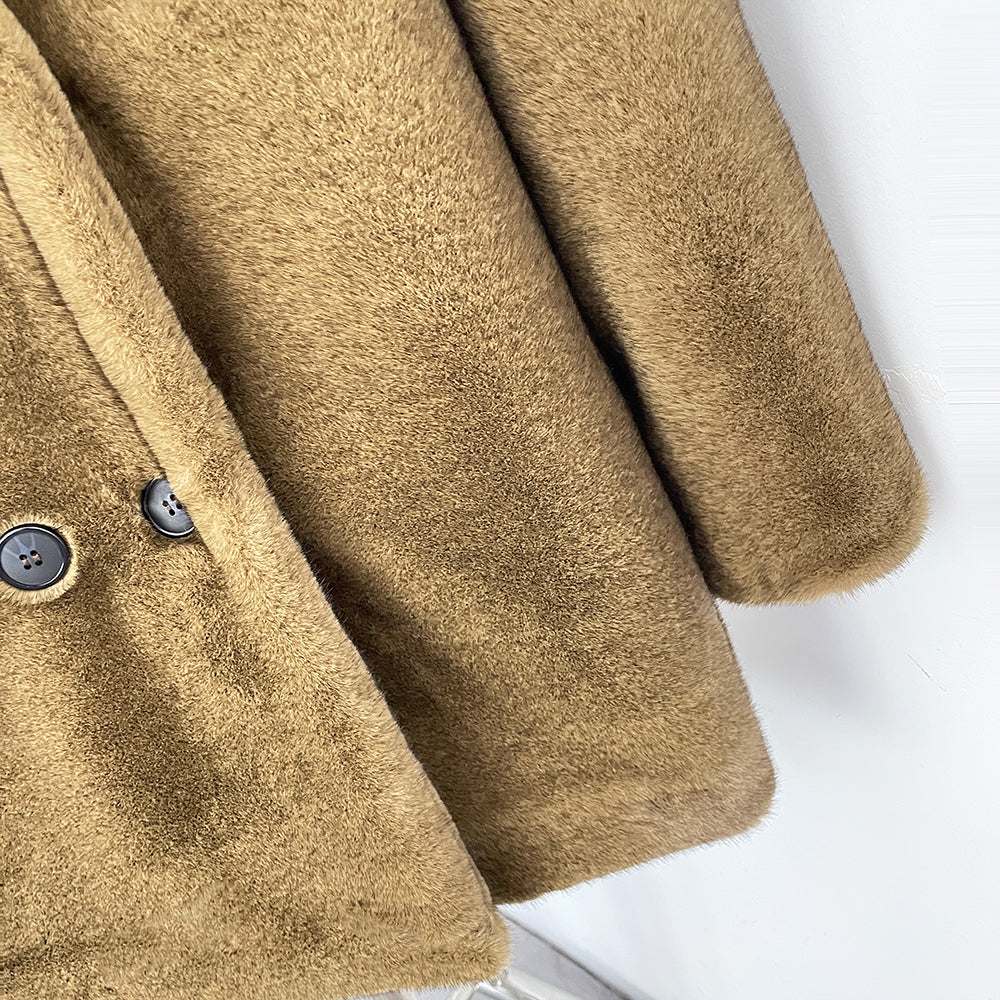 Detail shot of dark round double-breasted buttons on faux fur blazer